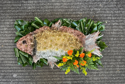 Fishing Tribute - A unique fish-shaped funeral tribute, handcrafted with intricate floral detail and a colourful finishing spray by Pursehouse Florist in Cannock.