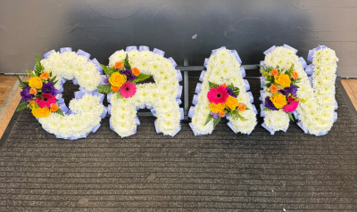 Letters - A beautiful personalised letter funeral tribute featuring a traditional white floral base, complemented by vibrant yellow, orange, pink and purple accents. Finished with delicate lilac ribbon edging, this colourful tribute offers a loving and meaningful way to celebrate the life of a much-loved grandad and honour the special memories you shared.